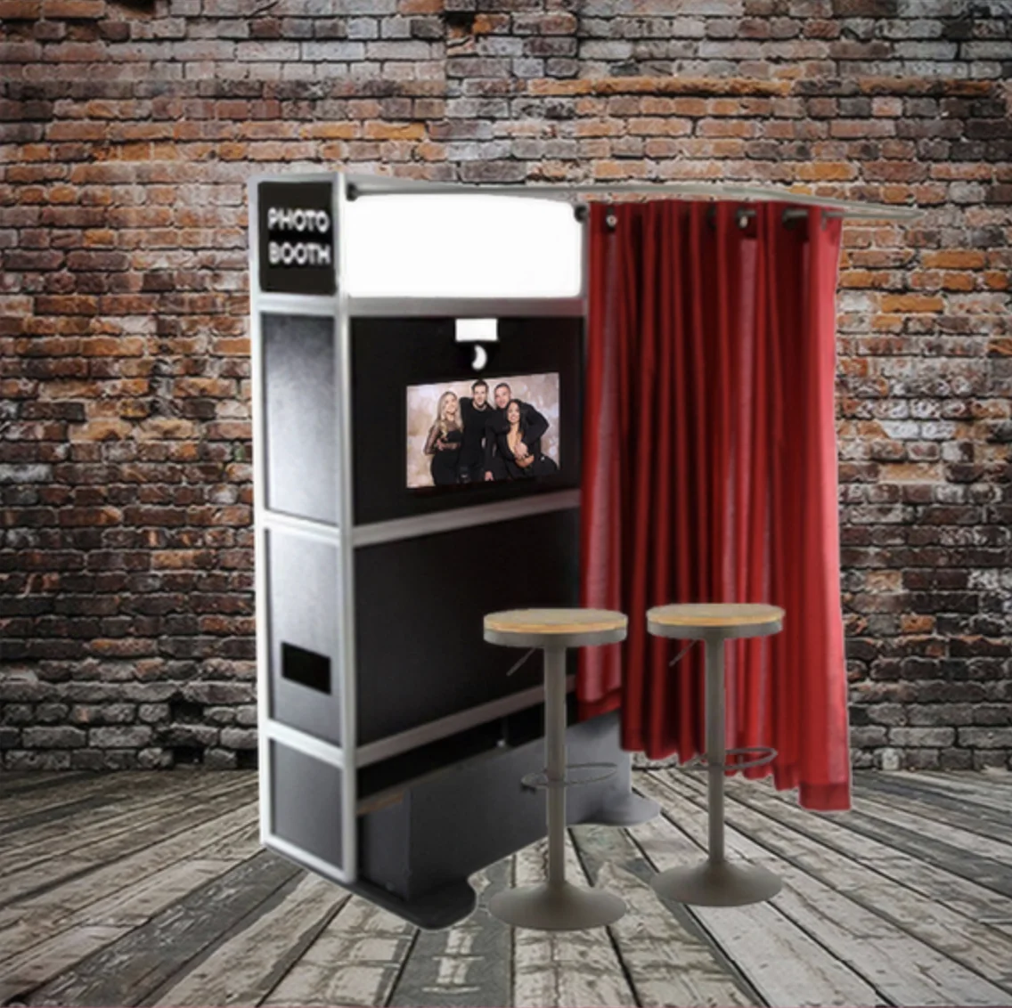 Traditional enclosed photo booth with red curtain and stools