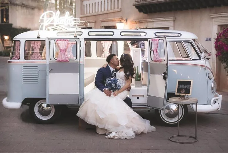 Newlyweds celebrating beside the VW Photo Bus