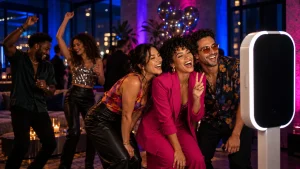 Friends posing at a photo booth during a colorful birthday party in a loft.